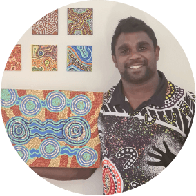 Travis standing with the Aboriginal artwork he created